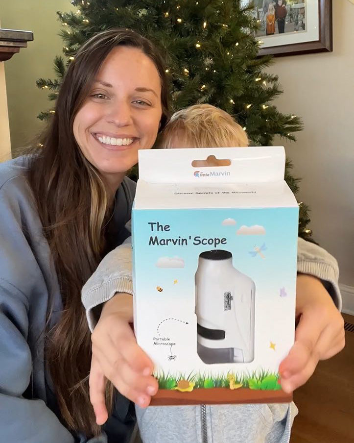 A child and mom unboxing a kids' microscope